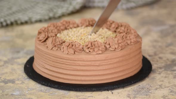 Delicious Chocolate Cake With Nuts. Cutting Chocolate Cake With A Kitchen Knife