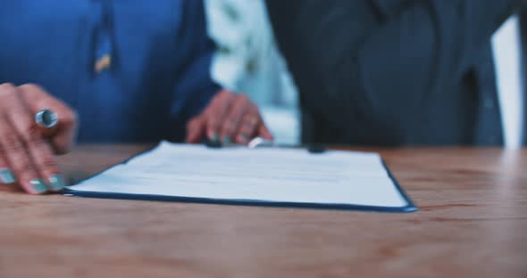 Close up of a busineswoman handing over a contract to a businessman