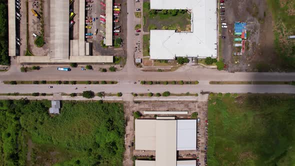 Cars and buses arrive at a local bus terminal with with shadows of clouds can be seen