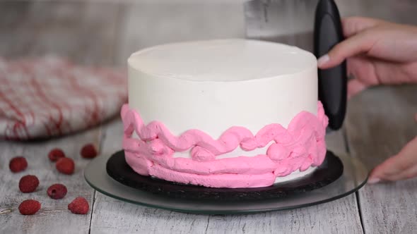 Close-up of woman decorating cake.	