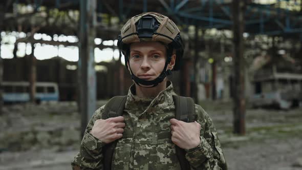 Female Soldier Standing at Factory and Looking at Camera