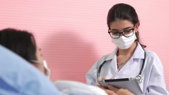 Doctor Wearing Face Mask Proficiently Talks with Patient at Hospital Ward