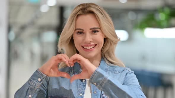 Attractive Young Woman with Heart Sign