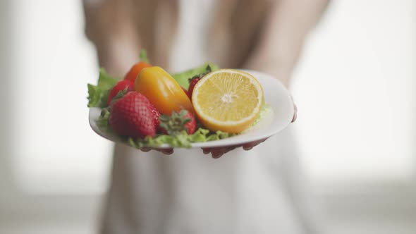 A Woman is Giving the Fresh Fruits on Plate