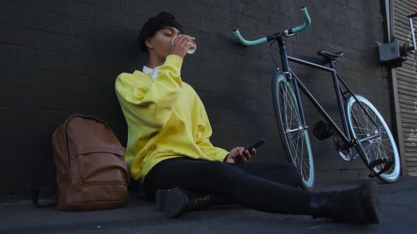 Transgender adult drinking coffee in the street