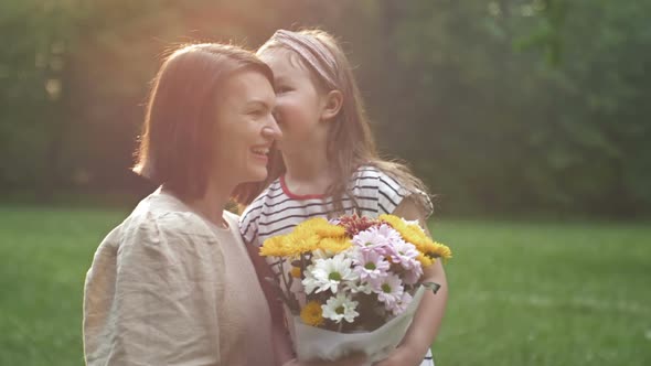 Little Girl Gives Flowers to Her Mother