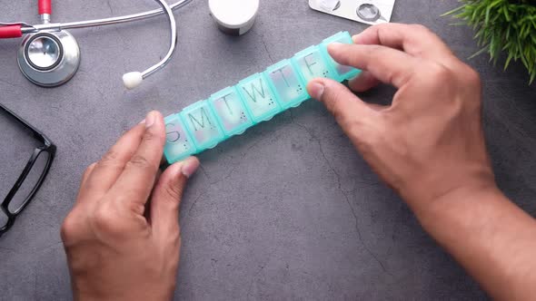 Top View of Man Hand Taking Medicine From Pill Box 