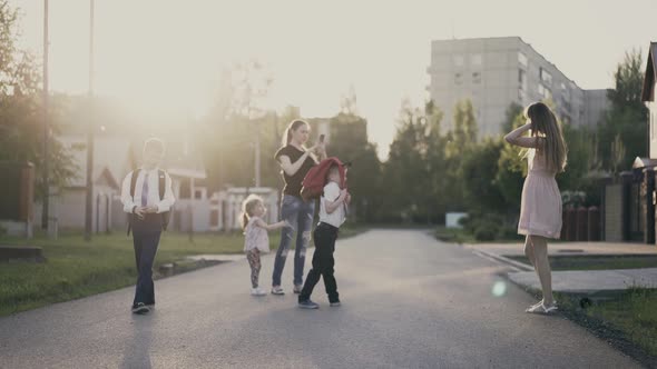 Students with Their Mothers are Photographed in the Courtyard After School Hours