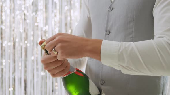 Young man opening champagne