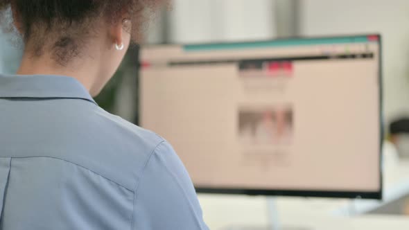 Rear View of African Woman Using Desktop