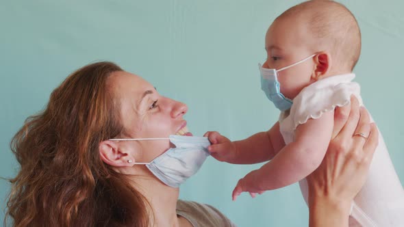Little Child Takes Off Mother's Mask. The Child Does Not Want To Wear a Medical Mask.