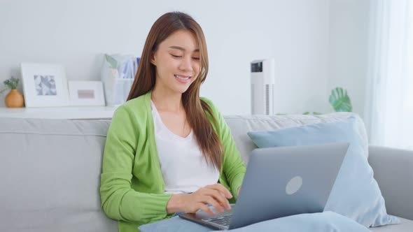 Portrait of Asian beautiful woman sit on sofa in living room at home.