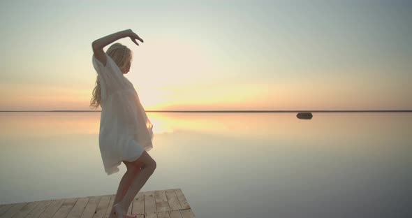 Beautiful Reflection of the Sunset Sky in the Background of a Woman Dancing