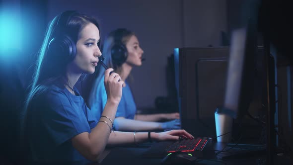 Two Women Playing an Online Game in the Gaming Club  a Woman Vaping on the Foreground