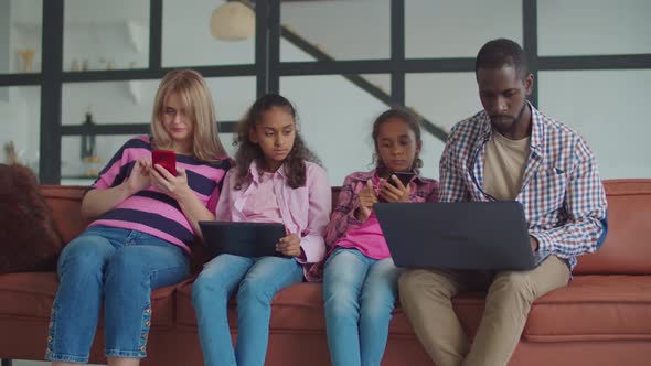 Diverse Family on Sofa Networking with Gadgets