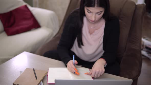 Student Making Notes Studying Online Looking at Laptop