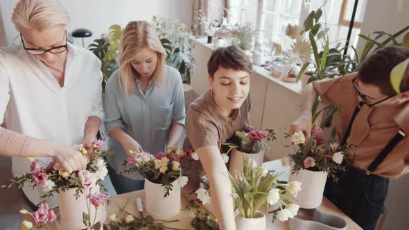 Young Man and Three Women Making Flower Bouquets on Floristics Masterclass