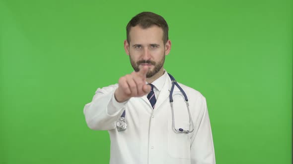 Young Male Doctor Gesturing to Call Him for Help Against Chroma Key
