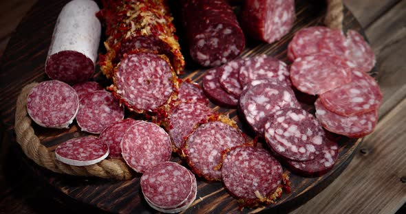 Cut Into Pieces of Various Types of Salami on the Table. 