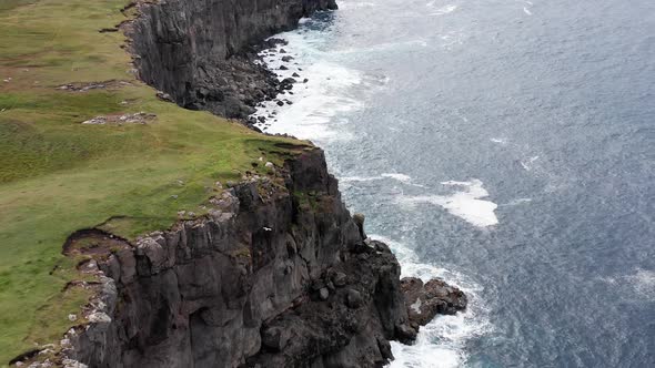 Aerial View High Rock Cliffs Ocean Waves Break on Cliffs