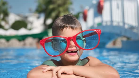 Funny Little Boy Wearing Big Glasses Laughing Posing in Swimming Pool Enjoying Summer Travel