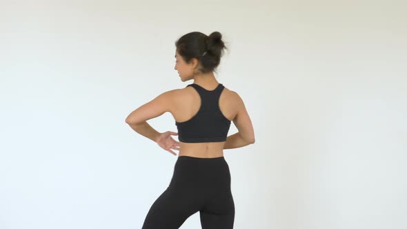 A young Indian Ballerina trains in a Gym, does a Spinning exercise, And Is dressed in a Black Top