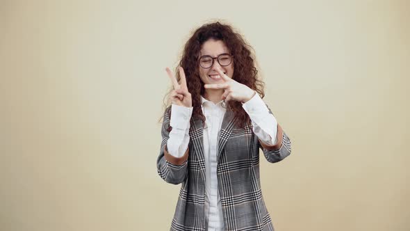 The Happy Smiling Young Woman Shows the Sign of Peace with Both Minis and at the End She Unites Them