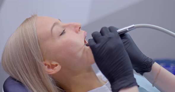 Dentist with Gloves Works with Dental Tools in the Patient's Oral Cavity