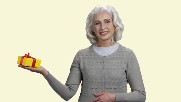 Mature Woman Holding Gift Box on White Background