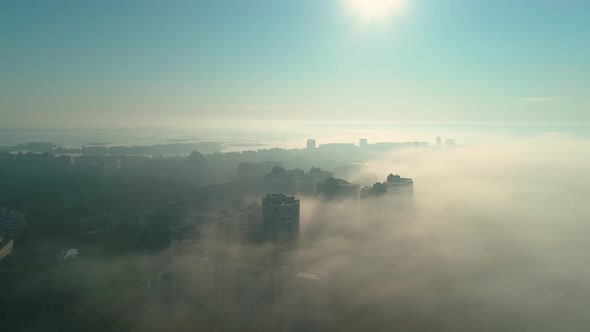 Aerial Drone Footage of Flying Over the City in Fog During Dawn