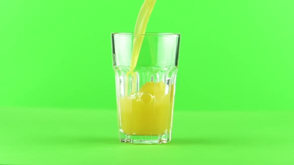 Juice Pouring Into Glass Isolated on Light Green Background Slow Motion