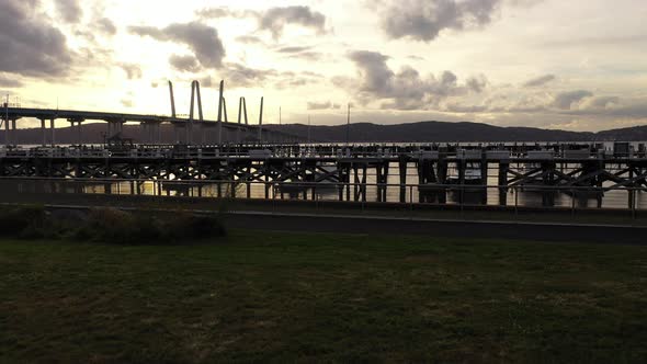 A low angle shot of the Tarrytown Marina with the Mario M. Cuomo Bridge in the background. The drone