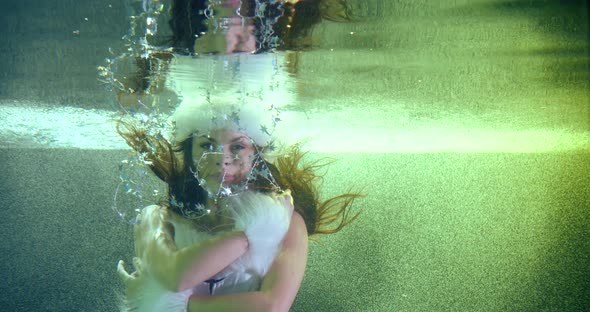 Portrait a Girl in a New Year's White Fluffy Suit, She Is Under Water, Makes Beautiful Movements