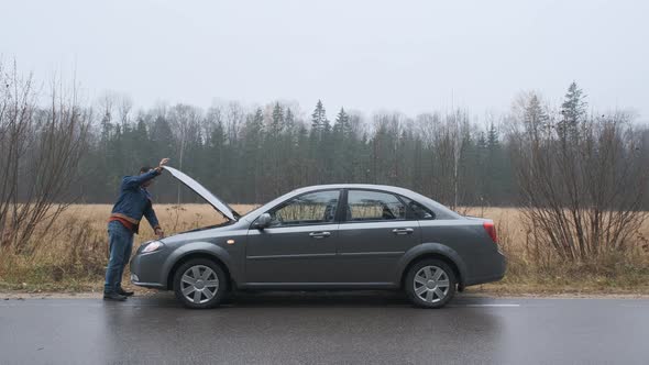 Man Opening Car Hood and Looking at Engine