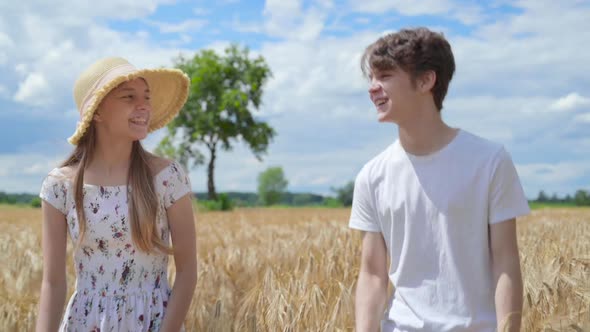 Girl and Boy Walking on Barley Field