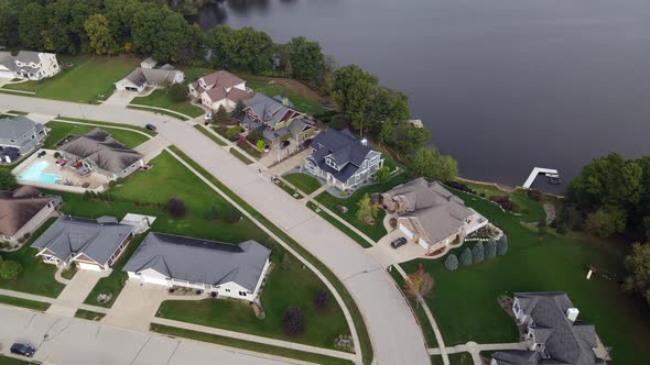 Aerial view of large residential homes along lake in western Wisconsin.  Trees lining water's edge.