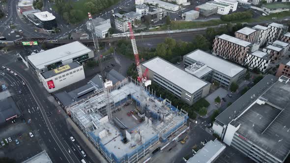 Buildings with cranes under construction downtown New Zealand at daytime, orbital aerial