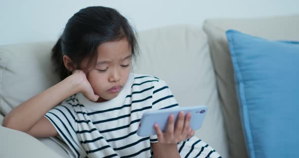 Little girl watch on cellphone at home