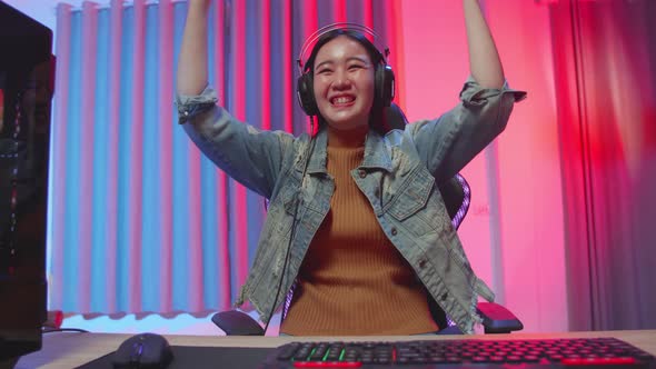 Excited Asian Girl Gamer Celebrates Victory While Playing Video Game On Computer