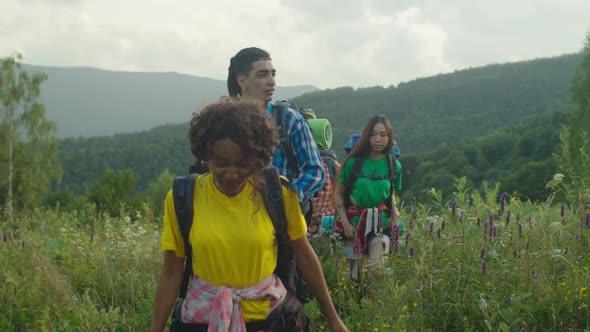 Group of Diverse Multiracial Hikers with Backpacks Enjoying Mountain Hiking at Sundown