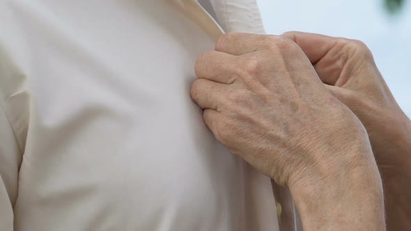 Mature Caring Lady Adjusting Buttons on Husband Shirt