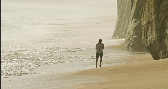 Caucasian Male Sportsman Jogs Along a Picturesque Shore