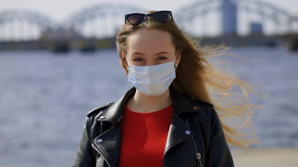 Beautiful Woman in Surgical Mask Looks at you