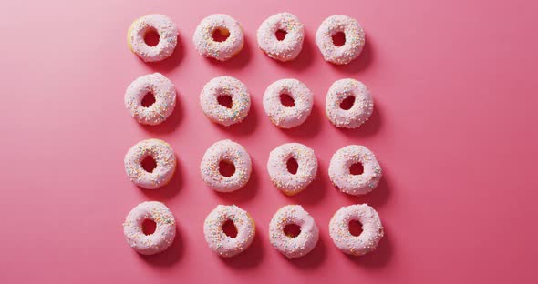 Video of donuts with icing on pink background