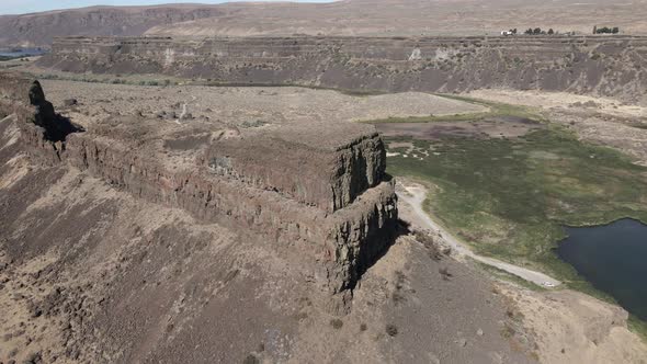 Panoramic Orbit of an enormous butte in the middle of Sun Lakes-Dry Falls State Park, aerial
