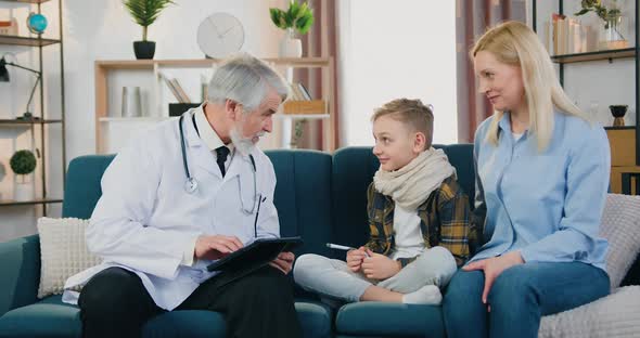 Doctor Talking with His Positive Boy Patient with Sore Throat and Giving Him High Five