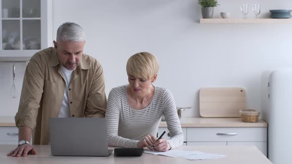 Wife Calculating Expenses Having Quarrel With Husband About Money Indoors