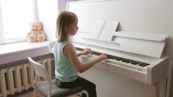 Little Girl Studying To Play the Piano at Home. Preschool Child Having Fun with Learning To Play