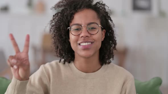 Portrait of African Woman with Victory Sign at Home