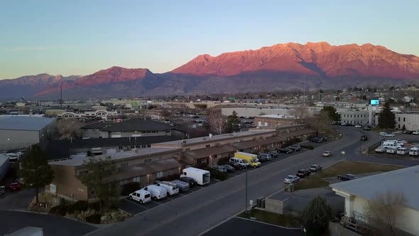 Aerial view rising above building to view mountain lit up by the sun